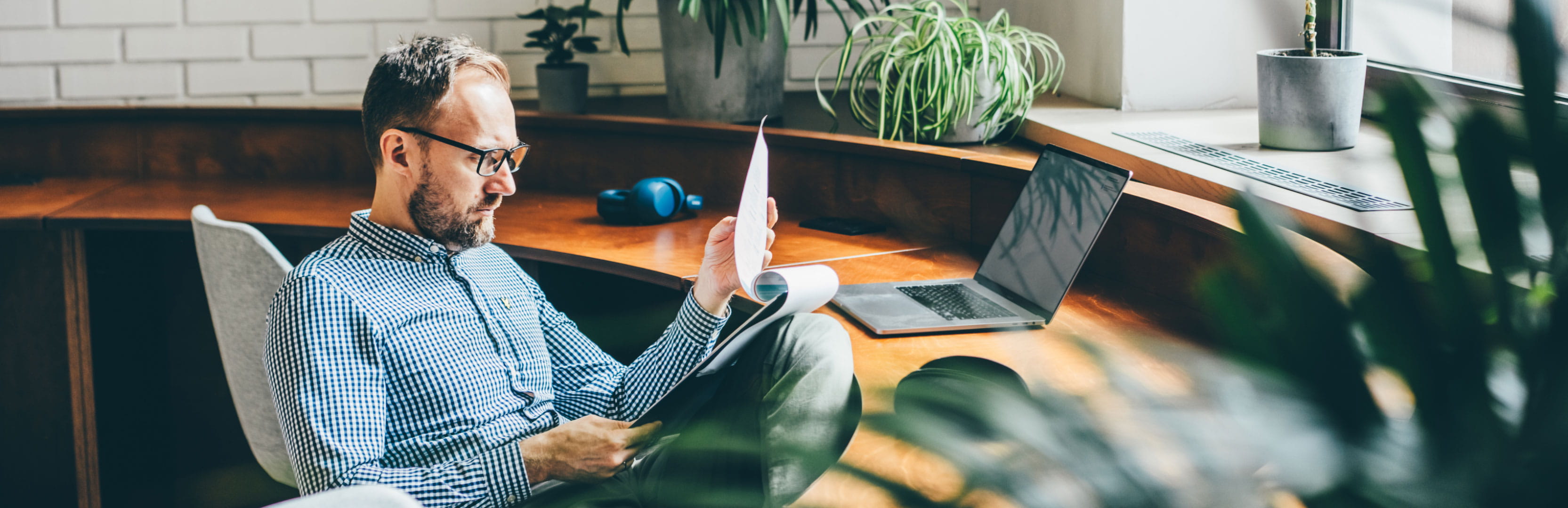 Person reviews financial documents at a desk, representing how active ETFs can simplify investing by providing diversified exposure through a single investment.
