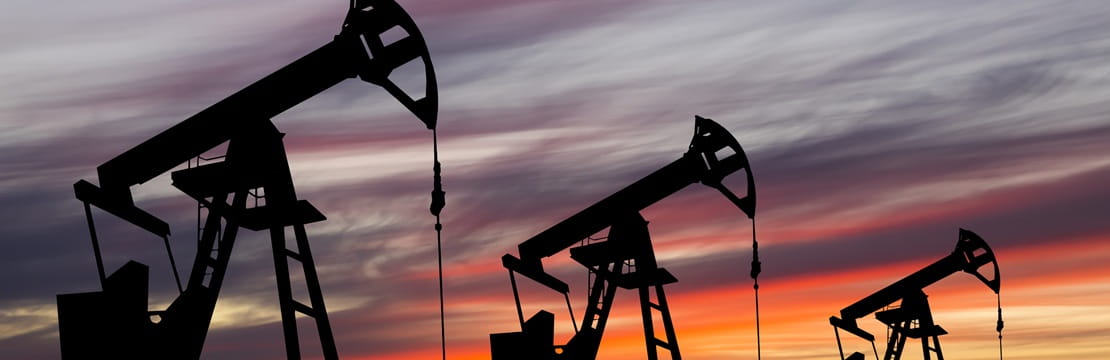 Oil pump jacks silhouetted at sunset, representing oil market volatility as a result of the US-Iran conflict.